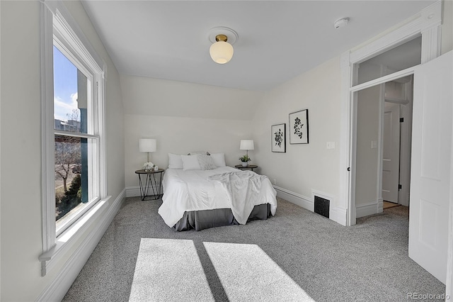 bedroom featuring carpet flooring, multiple windows, baseboards, and lofted ceiling