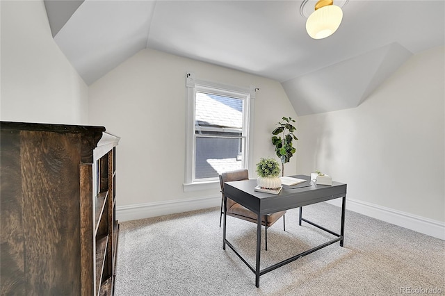 office space with baseboards, light carpet, and lofted ceiling