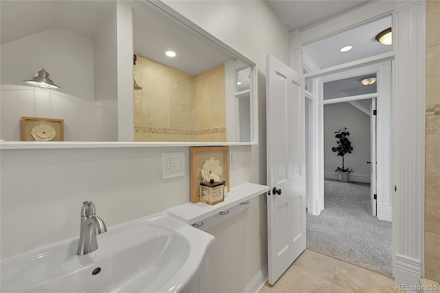 bathroom with a sink, lofted ceiling, and tile patterned flooring