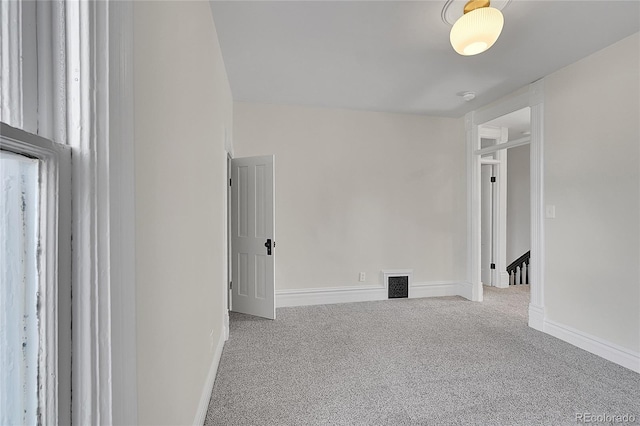 empty room featuring visible vents, carpet flooring, and baseboards