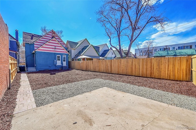 view of yard featuring a residential view, central AC unit, a patio, and a fenced backyard