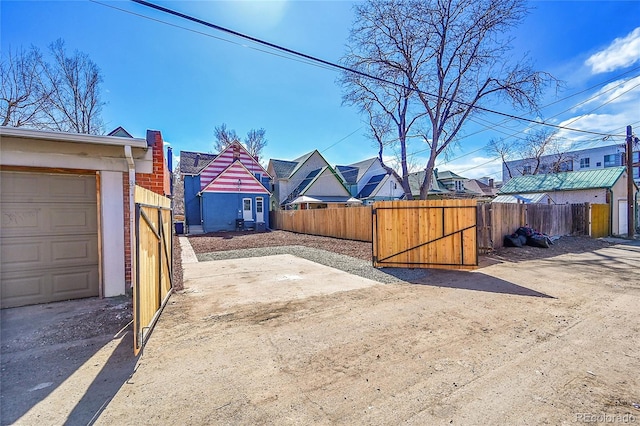 view of yard featuring a gate, fence, and a residential view