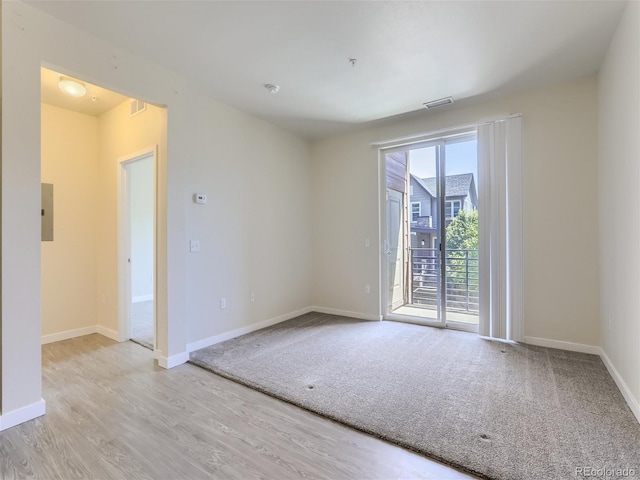 unfurnished room with electric panel and light carpet