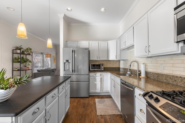 kitchen with stainless steel appliances, decorative backsplash, ornamental molding, white cabinets, and a sink