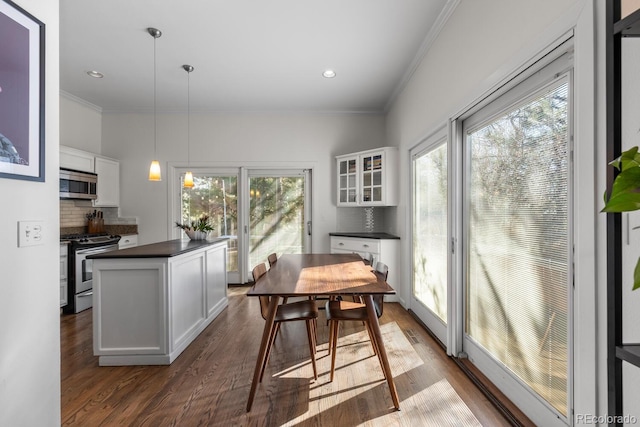 kitchen featuring stainless steel appliances, dark countertops, decorative backsplash, and white cabinets