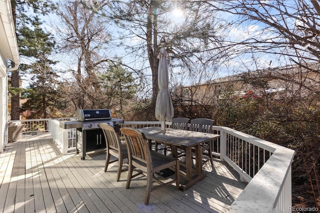 wooden deck with outdoor dining area and area for grilling