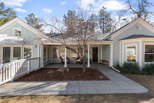 view of front of home featuring a shingled roof and a chimney