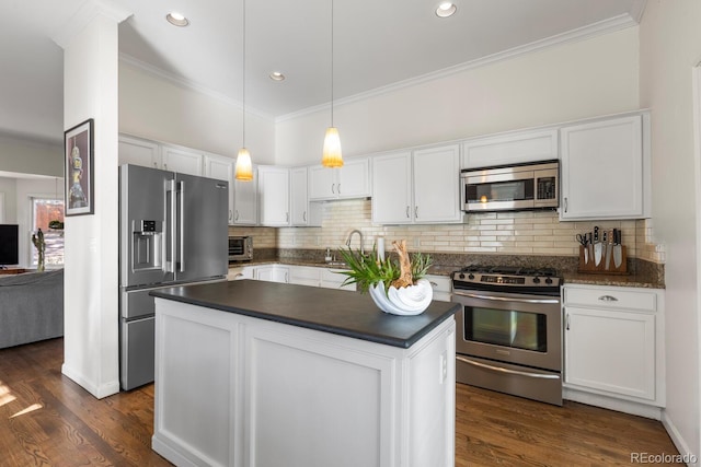 kitchen with stainless steel appliances, dark countertops, and white cabinetry