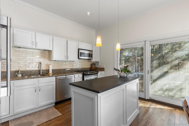 kitchen featuring stainless steel appliances, white cabinetry, a sink, and crown molding