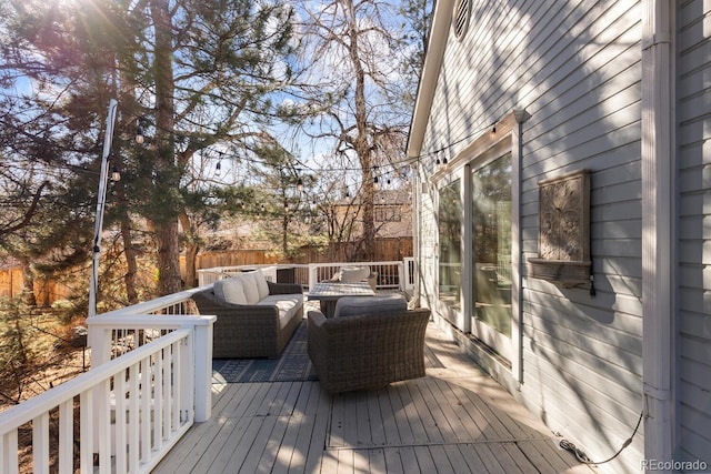 wooden terrace featuring outdoor lounge area and fence