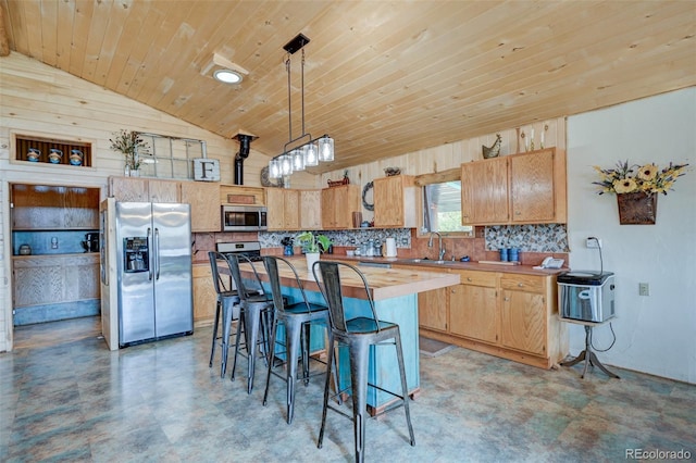 24700 US Highway 285, Buena Vista, CO 81211 - kitchen featuring stainless steel appliances, lofted ceiling, a breakfast bar, decorative backsplash, and a kitchen island