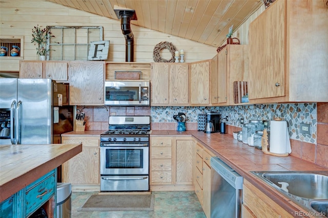 24700 US Highway 285, Buena Vista, CO 81211 - kitchen featuring stainless steel appliances, tile countertops, lofted ceiling, backsplash, and light brown cabinetry