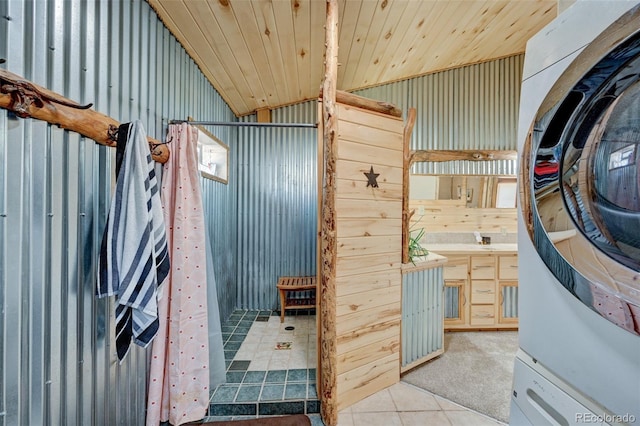 24700 US Highway 285, Buena Vista, CO 81211 - bathroom with stacked washer and clothes dryer, tile patterned floors, and lofted ceiling