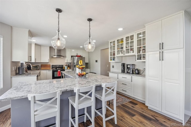 kitchen featuring black range with electric cooktop, wall chimney range hood, stainless steel fridge with ice dispenser, white cabinets, and recessed lighting