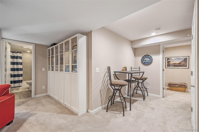 hallway with carpet flooring and baseboards