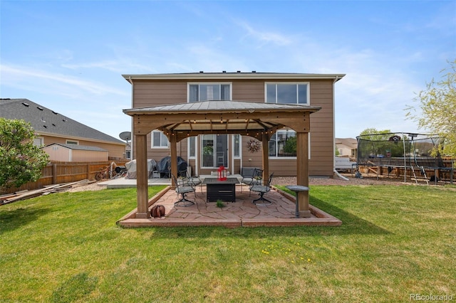 back of property with a trampoline, a gazebo, and a patio area