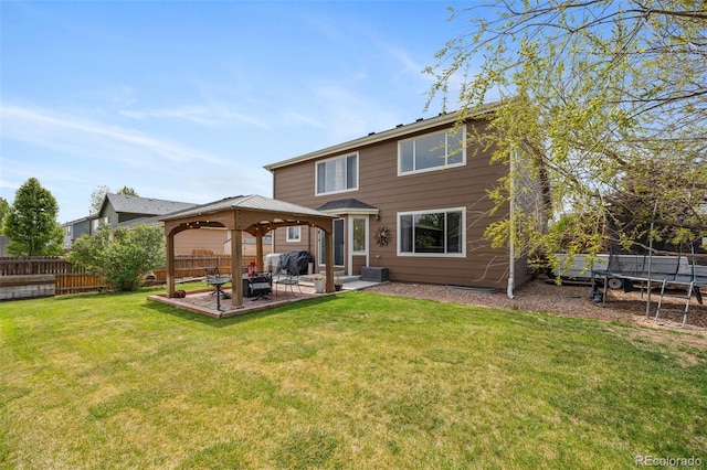 back of property with a gazebo, a patio area, and a trampoline