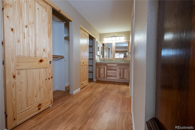 hallway with baseboards and light wood-style floors