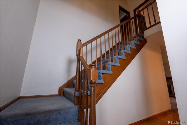 staircase featuring baseboards and carpet
