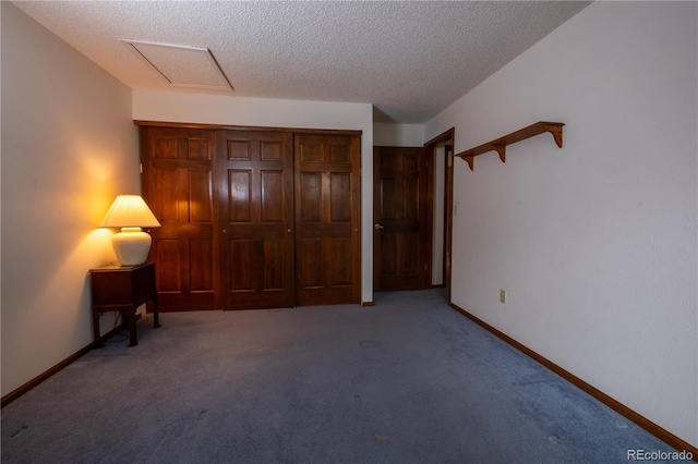 unfurnished bedroom with a textured ceiling, baseboards, and carpet