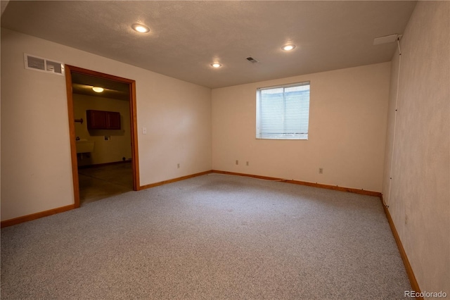unfurnished room with baseboards, light colored carpet, and visible vents