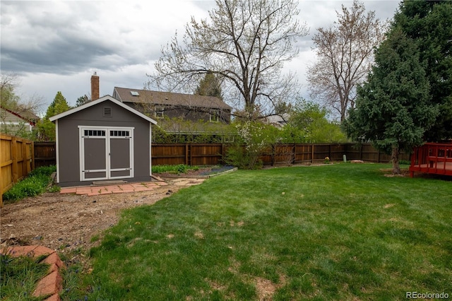 view of yard featuring a fenced backyard, an outdoor structure, and a shed