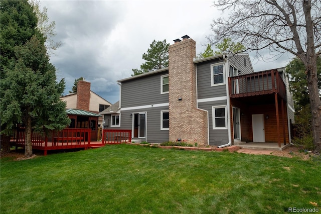 back of house featuring a lawn, a gazebo, a chimney, and a wooden deck