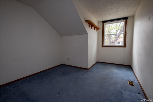 bonus room featuring carpet floors, visible vents, lofted ceiling, baseboards, and a textured ceiling