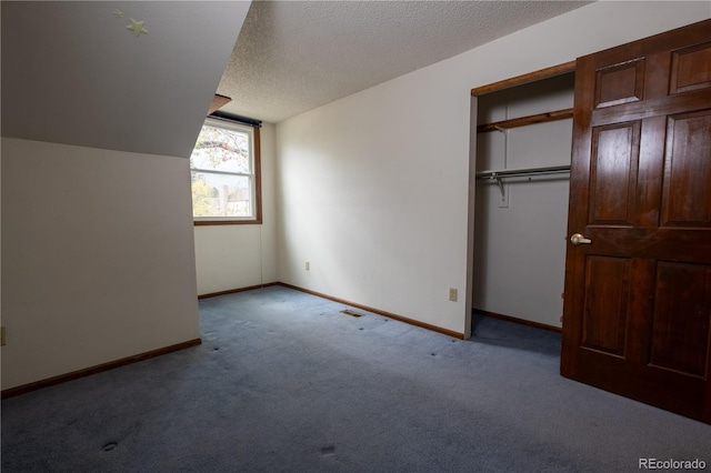 unfurnished bedroom with visible vents, carpet floors, a textured ceiling, baseboards, and vaulted ceiling