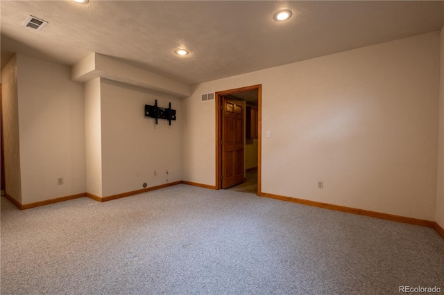 empty room with visible vents, baseboards, and light colored carpet