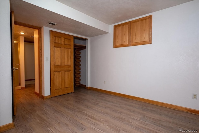 interior space featuring baseboards, light wood-type flooring, and visible vents