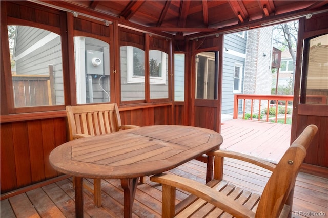 sunroom featuring wooden walls, wooden ceiling, hardwood / wood-style floors, and a deck