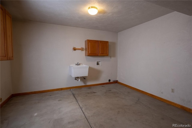 laundry area featuring cabinet space, washer hookup, a sink, and baseboards