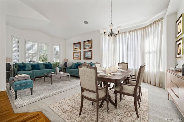 dining area featuring vaulted ceiling and a chandelier