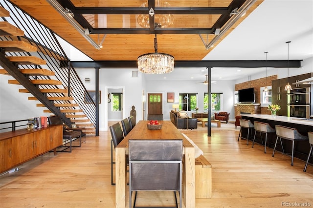 2669 N Cherry St, Denver, CO 80207 - dining space featuring light wood finished floors, a chandelier, stairs, a ceiling fan, and a towering ceiling