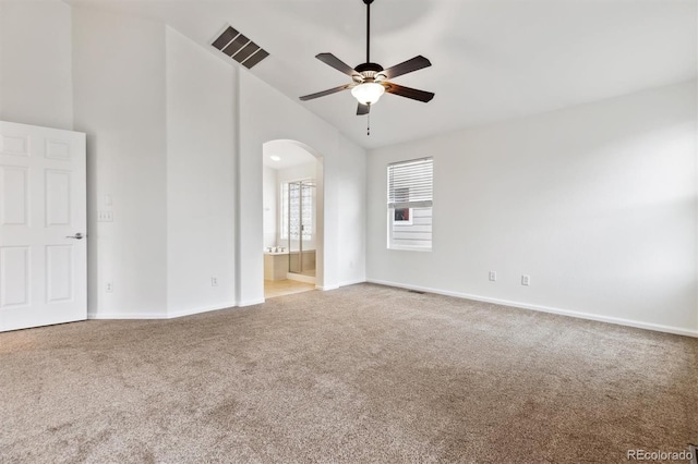 unfurnished bedroom with arched walkways, baseboards, visible vents, and carpet