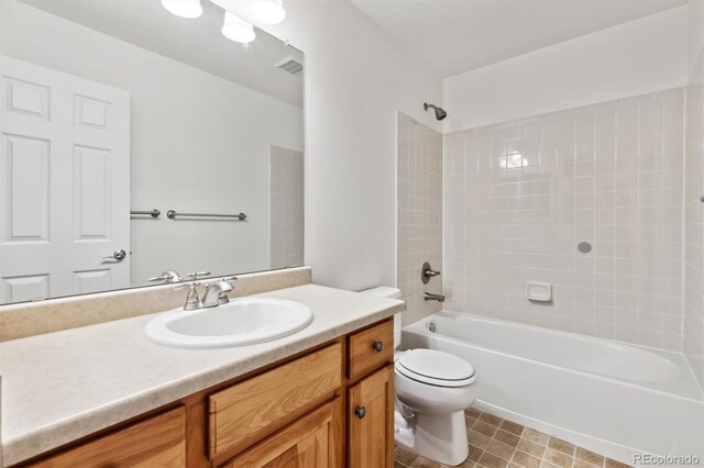 full bath with toilet,  shower combination, vanity, and visible vents