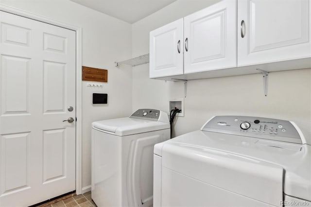 clothes washing area featuring cabinet space and washing machine and clothes dryer