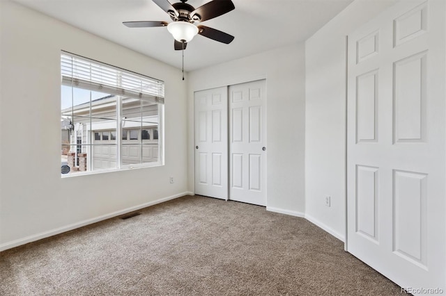 unfurnished bedroom featuring carpet, a closet, visible vents, and baseboards