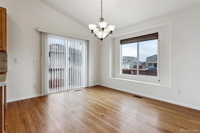 unfurnished dining area with a chandelier, visible vents, baseboards, vaulted ceiling, and light wood-type flooring