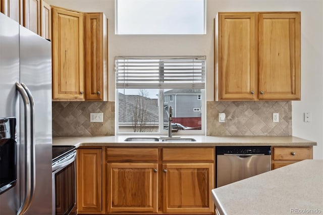 kitchen featuring tasteful backsplash, stainless steel appliances, a sink, and light countertops