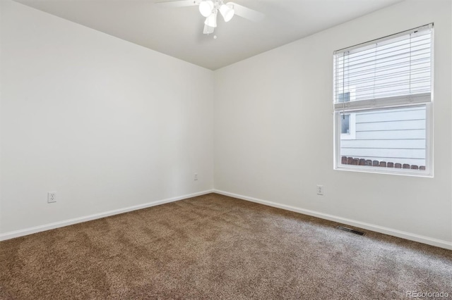 carpeted spare room with visible vents, ceiling fan, and baseboards