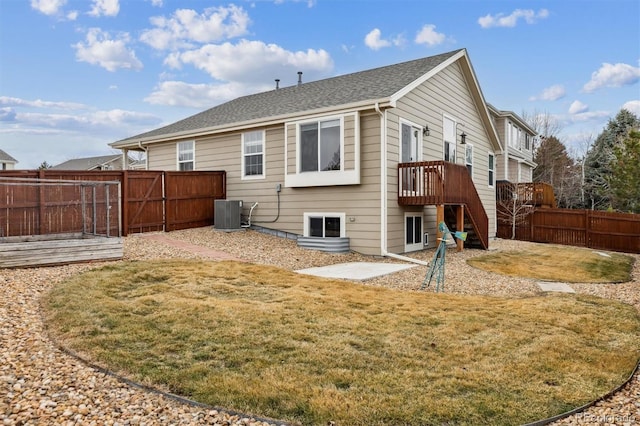 back of property featuring a yard, central air condition unit, stairway, fence, and a deck