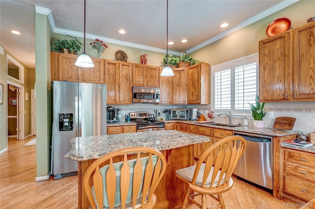 10292 Nickolas Ave, Highlands Ranch, CO 80130 - kitchen featuring stainless steel appliances, a center island, decorative backsplash, light wood finished floors, and crown molding