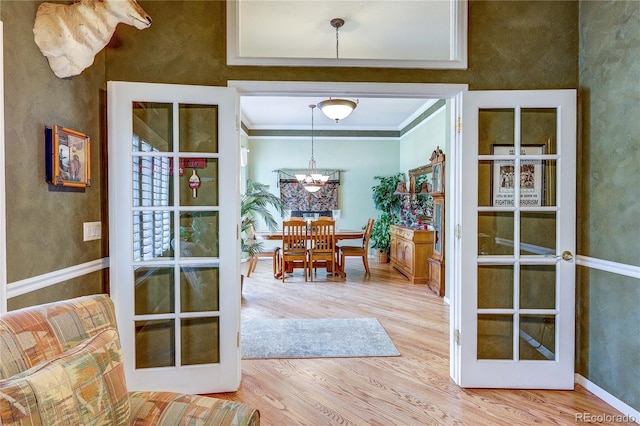 10292 Nickolas Ave, Highlands Ranch, CO 80130 - dining space featuring wood finished floors, a chandelier, ornamental molding, and french doors