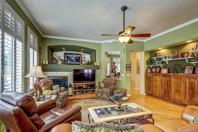 10292 Nickolas Ave, Highlands Ranch, CO 80130 - living room with plenty of natural light, ornamental molding, wood finished floors, ceiling fan, and a tiled fireplace