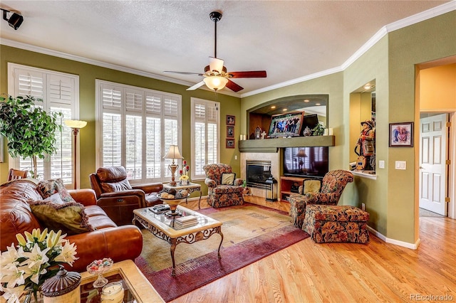 10292 Nickolas Ave, Highlands Ranch, CO 80130 - living room with wood finished floors, ornamental molding, a ceiling fan, and a fireplace