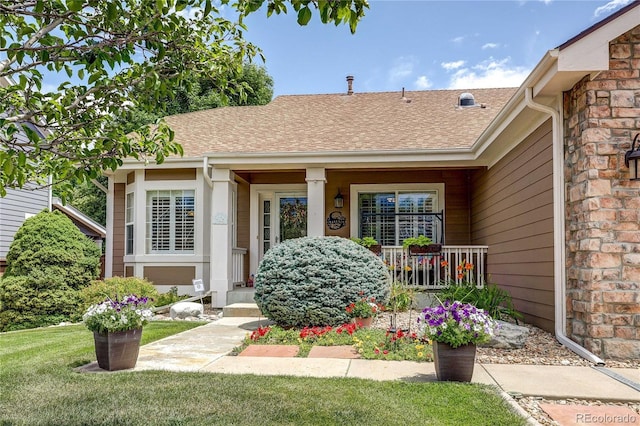 10292 Nickolas Ave, Highlands Ranch, CO 80130 - view of exterior entry featuring covered porch, a shingled roof, and a lawn