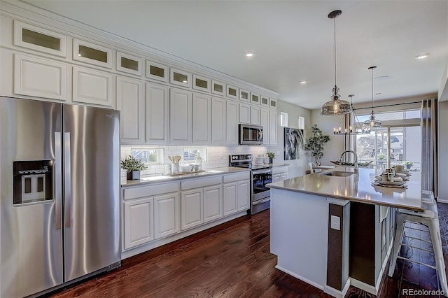 kitchen featuring appliances with stainless steel finishes, sink, white cabinetry, and a center island with sink