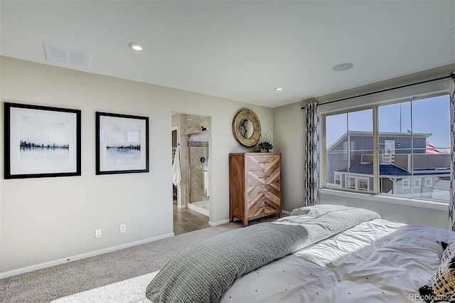 bedroom featuring ensuite bathroom and carpet flooring